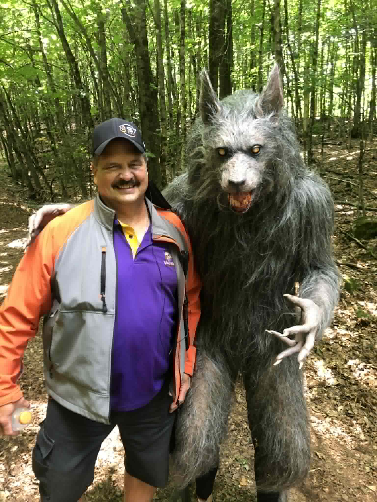 Chris posing with a werewolf in the woods